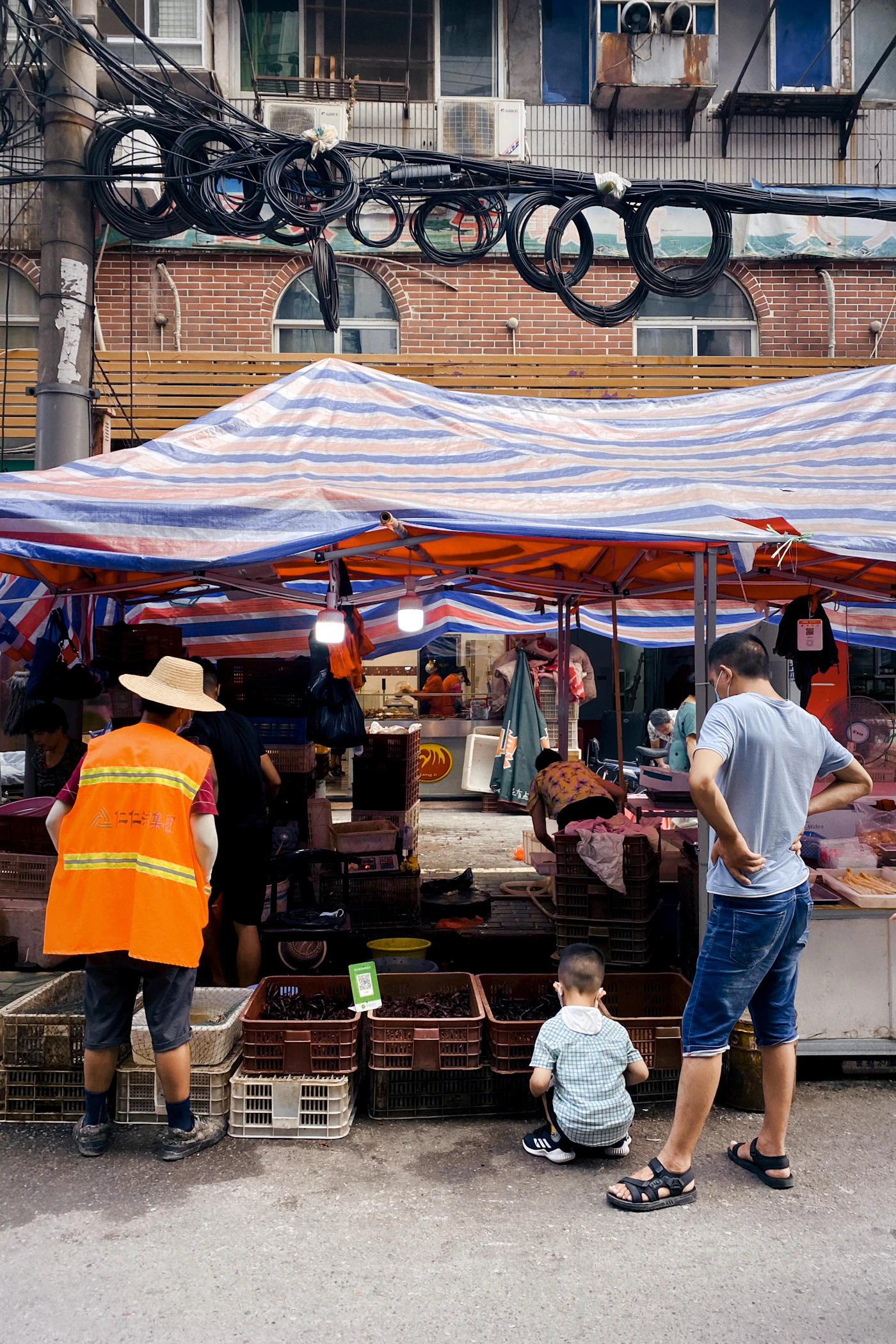 Food sellers working beneath colorful tarpaulins