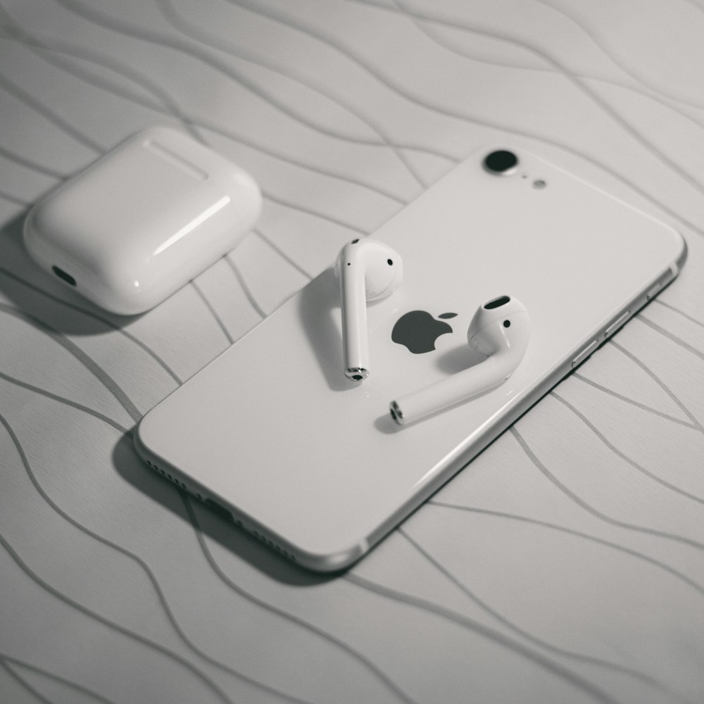 white apple earpods on white textile