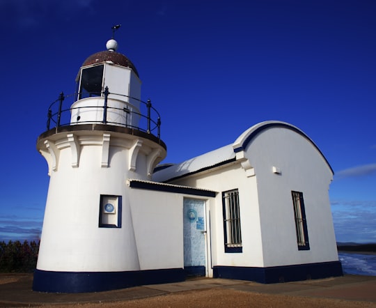 white and black concrete building under blue sky during daytime in Tacking Point Lighthouse Australia