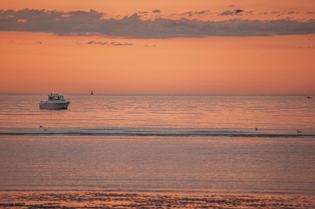 white boat on sea during sunset