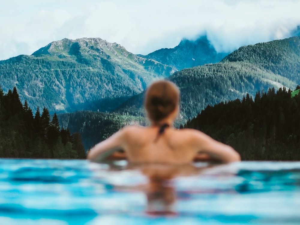 woman in blue swimming pool during daytime