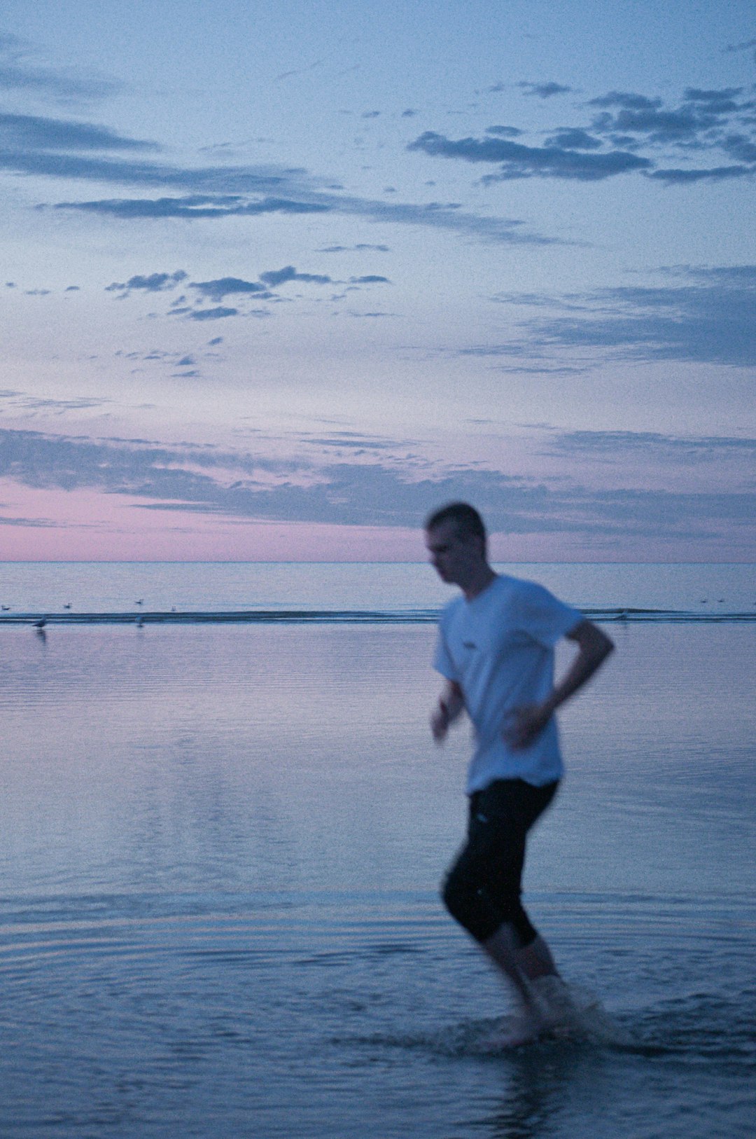 man in black shorts running on water during daytime