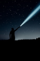 silhouette of man holding flashlight