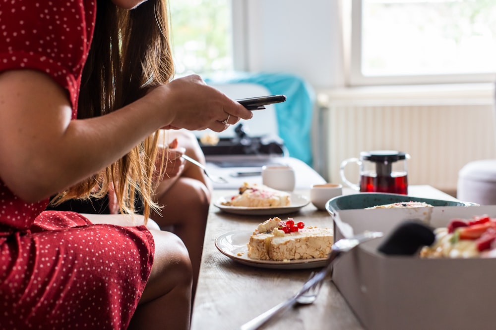 woman in red tank top holding fork and knife