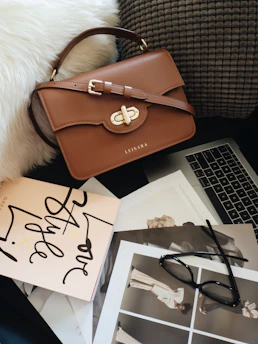 A beautifully styled chunky handmade bag resting on a warm, textured surface.