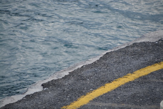 grey and yellow concrete road near body of water during daytime in Heraklion Greece