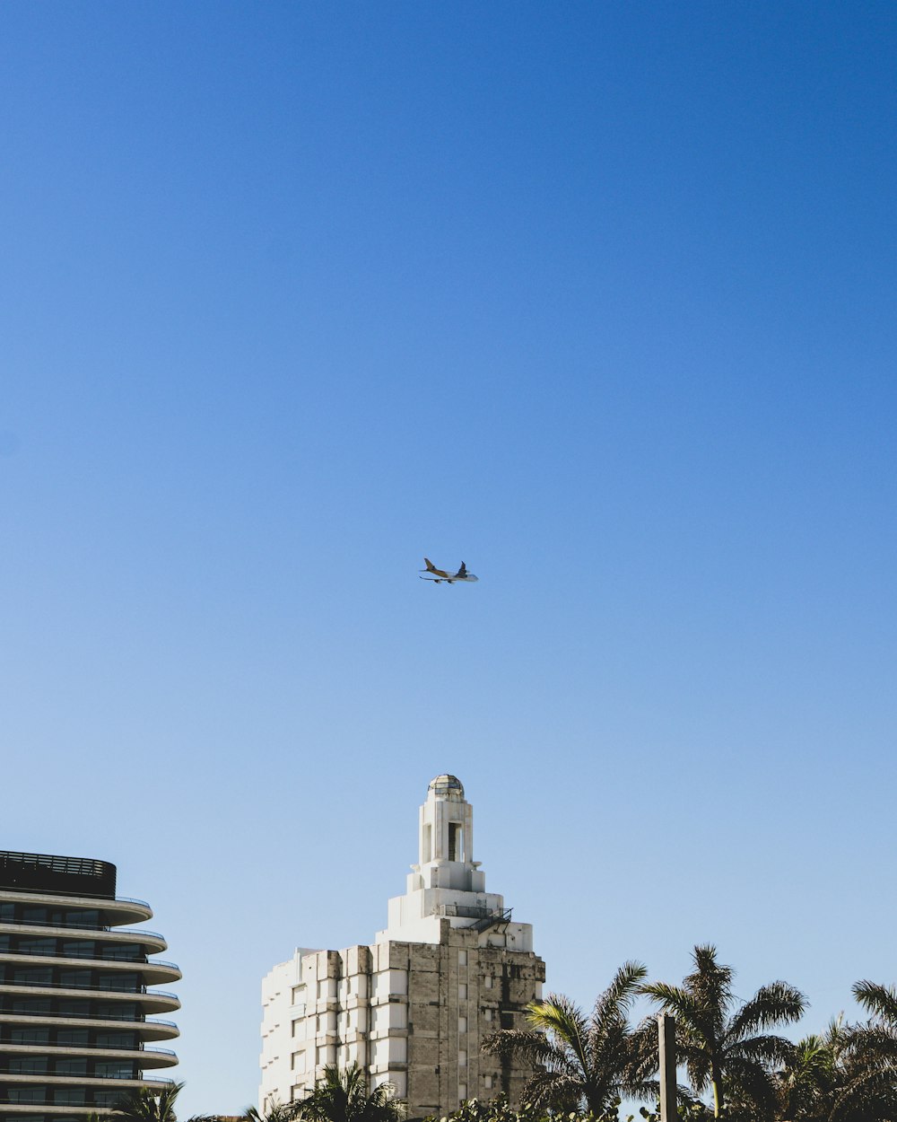 airplane flying over city buildings during daytime