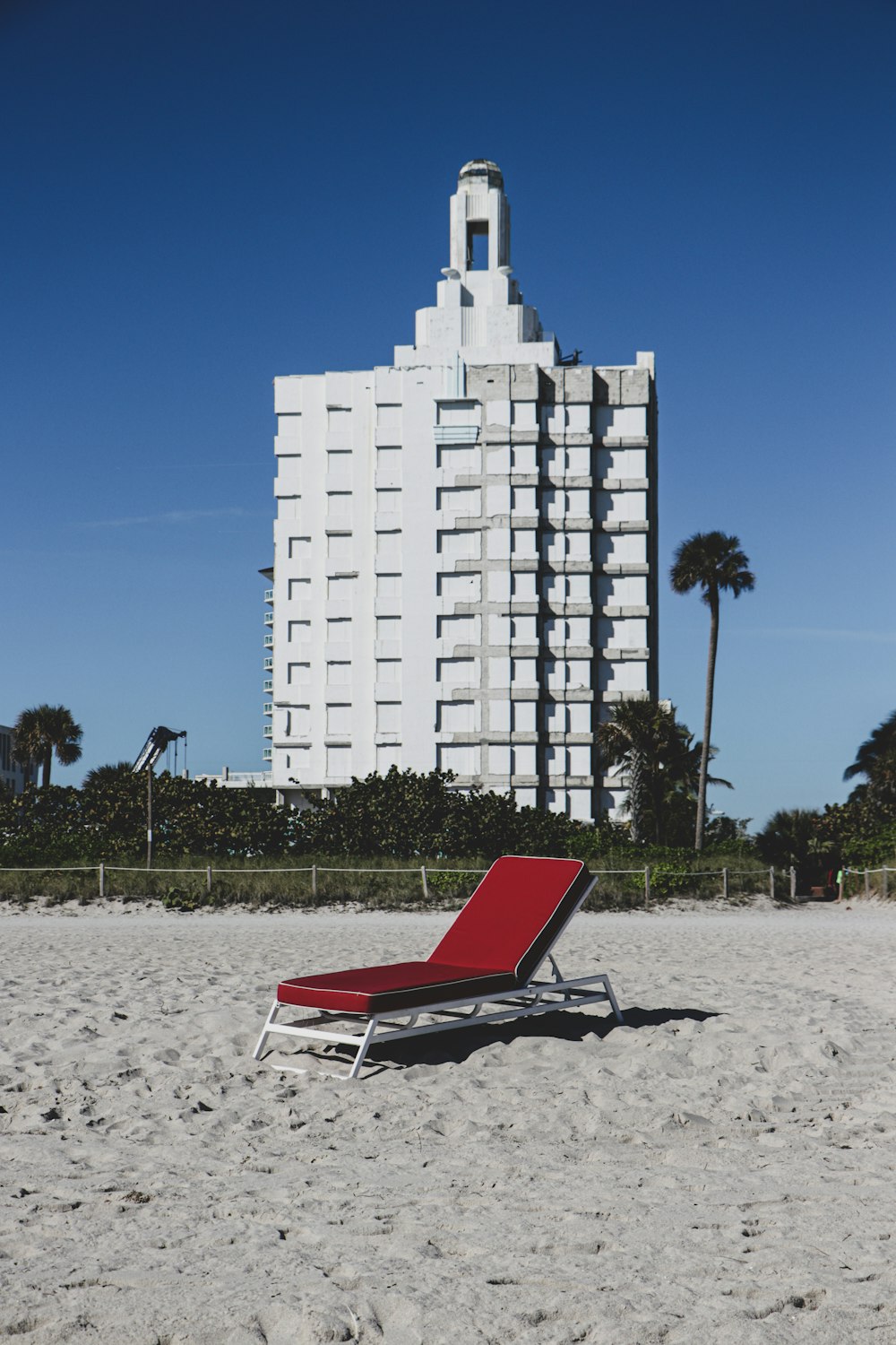 red and white lounge chair on beach during daytime