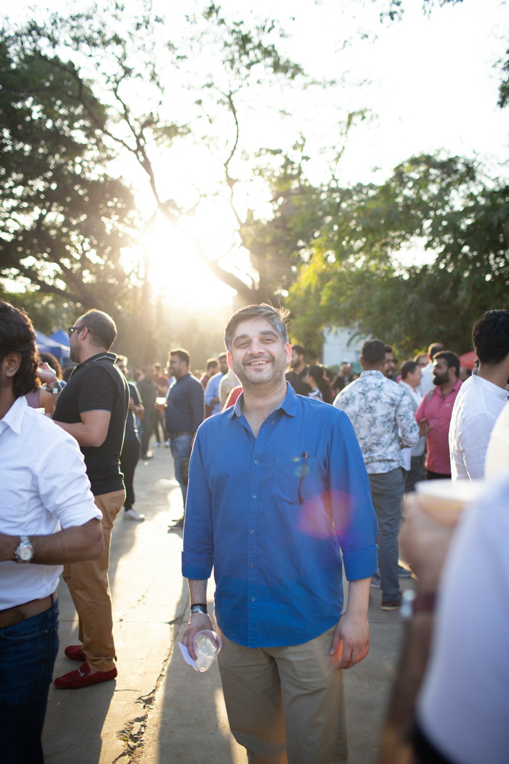 man in blue polo shirt standing near people during daytime