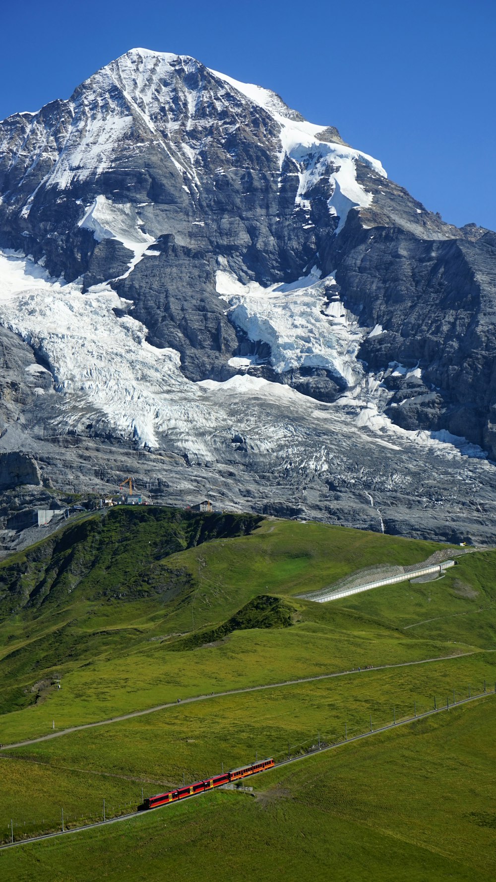 Campo de hierba verde cerca de la montaña cubierta de nieve durante el día