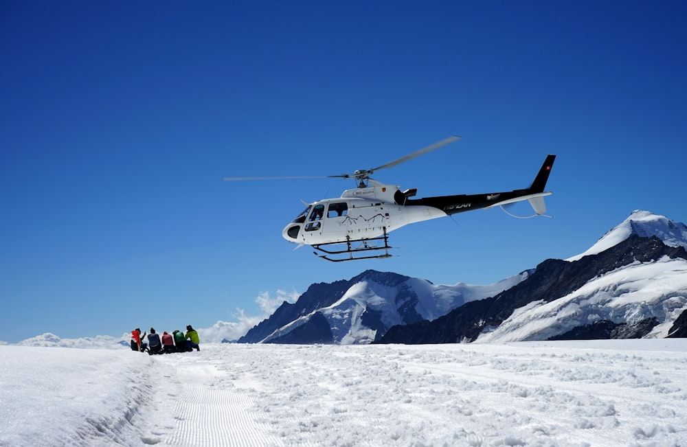 white and black drone flying over snow covered mountain during daytime