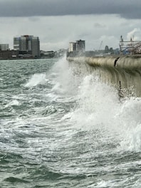 Construction workers building a sturdy sea defense wall along the coastline.
