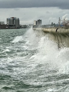 Construction workers building a sturdy sea defense wall along the coastline.