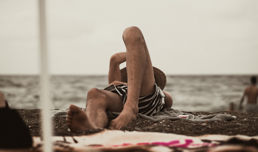 woman in black and white stripe bikini lying on beach sand