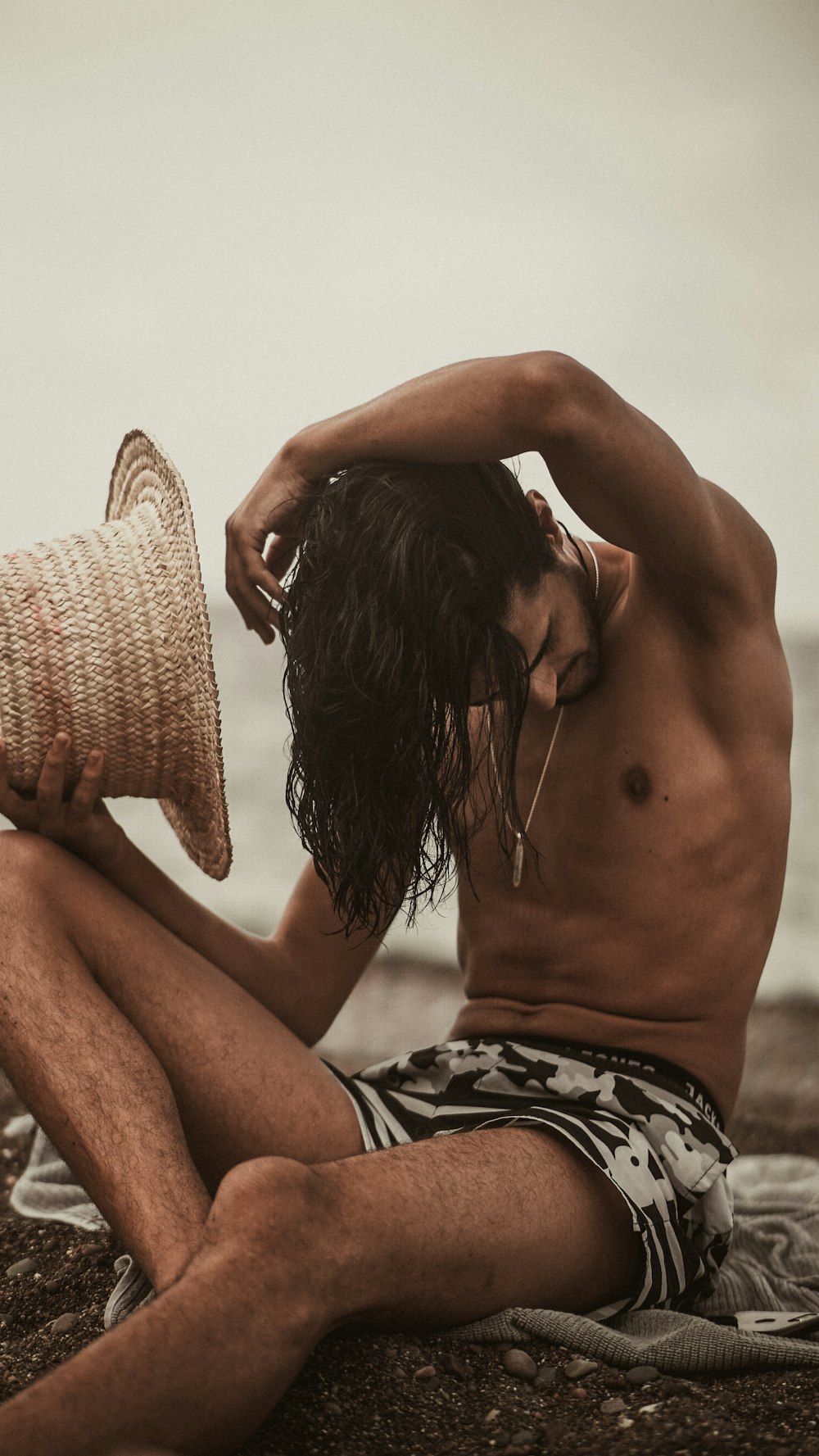 topless woman covering her face with brown knit hat