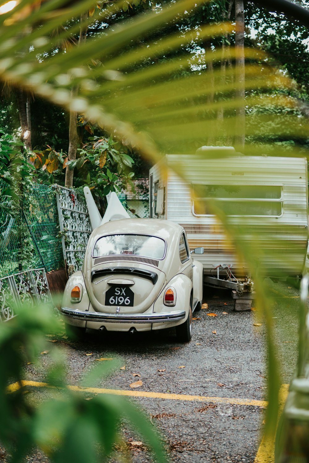 white volkswagen beetle parked on gray concrete road during daytime