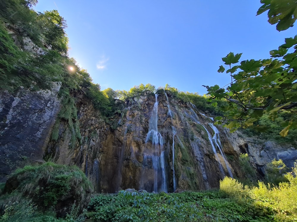 green trees near brown mountain under blue sky during daytime