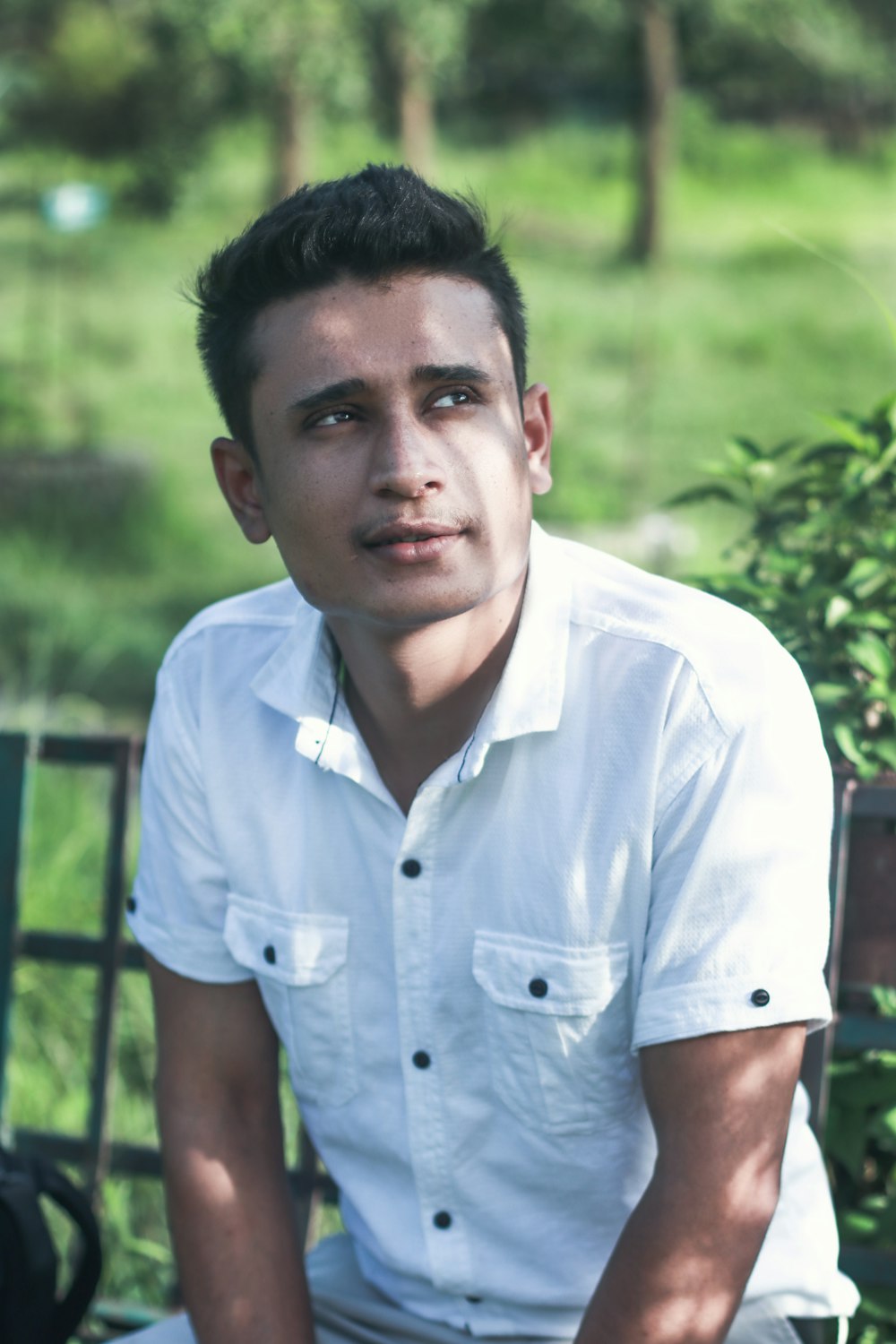 man in white button up shirt standing near green grass during daytime