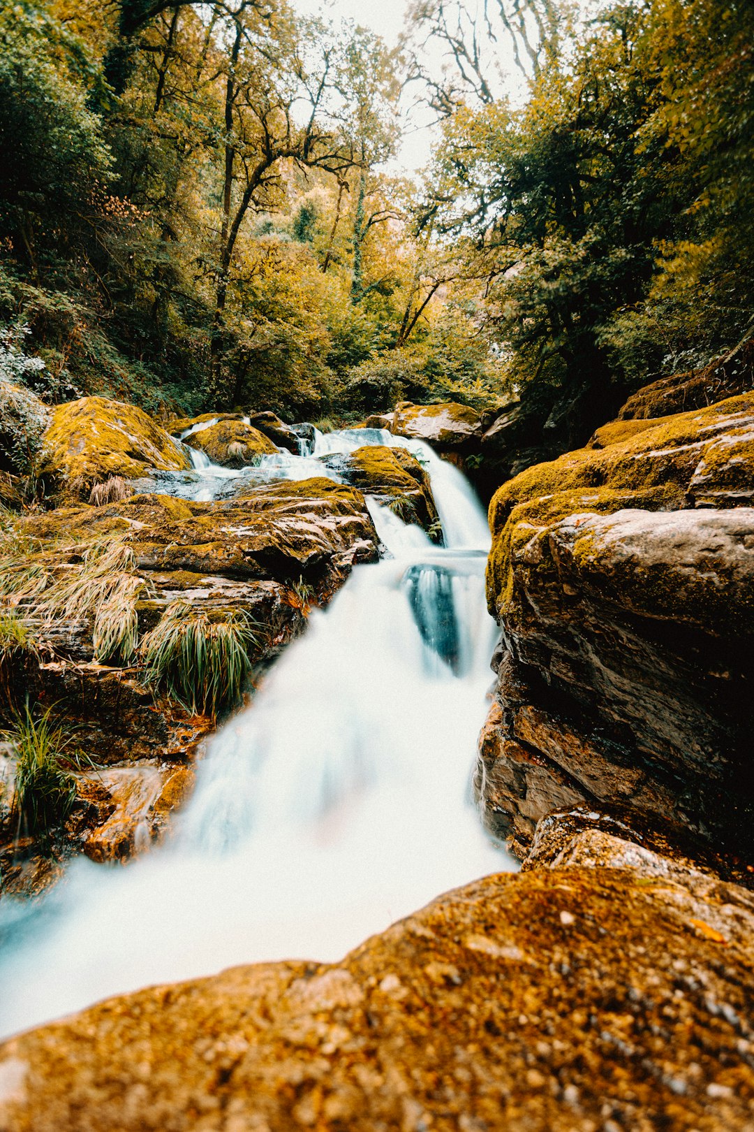 water falls in the middle of brown rocks