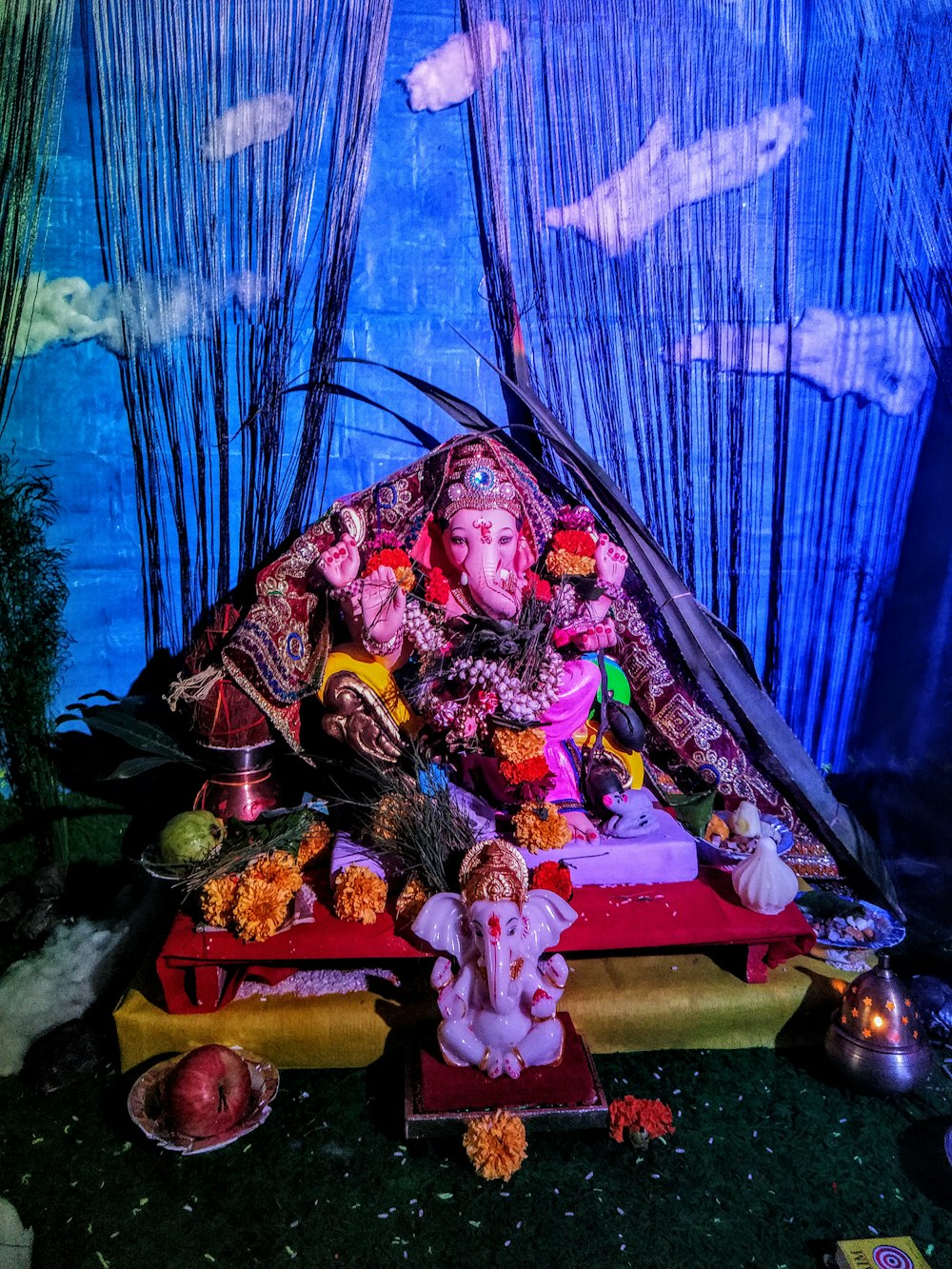 a statue of lord ganesh in front of a blue curtain