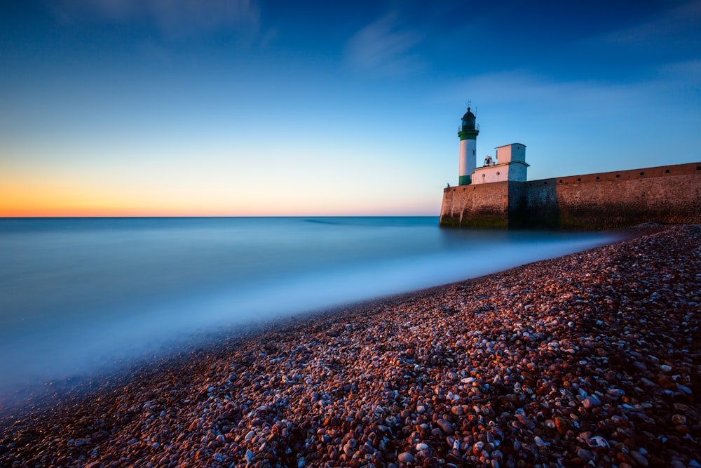 brown concrete lighthouse near sea during daytime