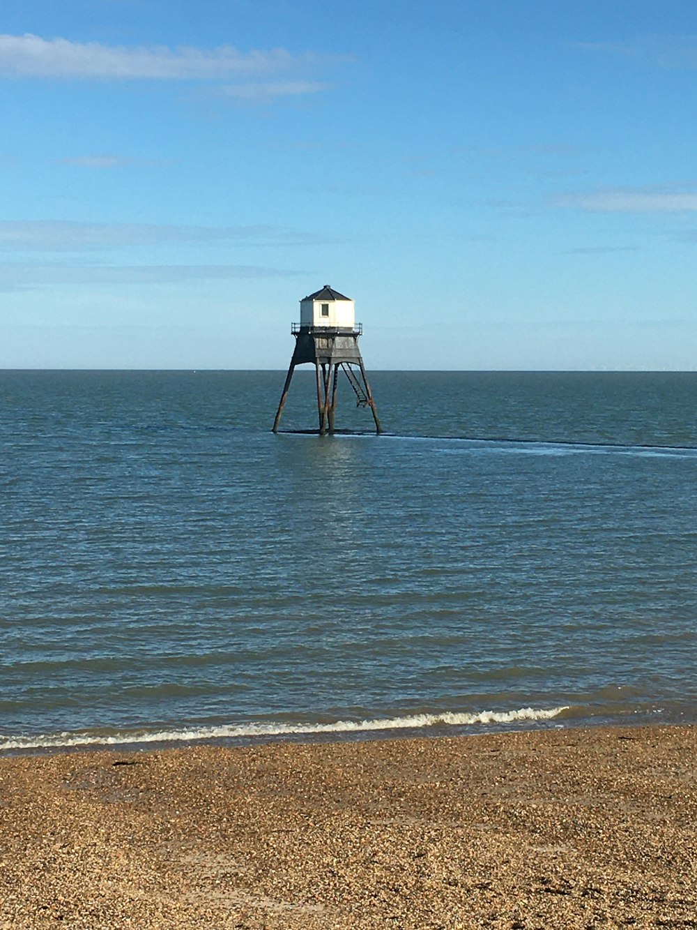 white and black lifeguard tower on beach during daytime