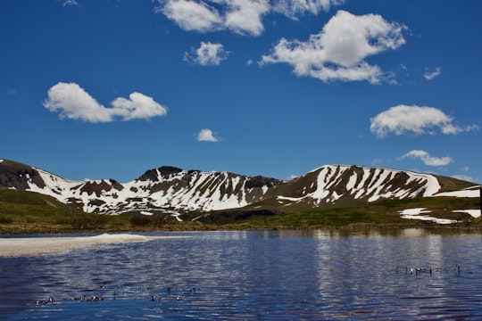 snow covered mountain near body of water under blue sky during daytime in Independence Pass United States