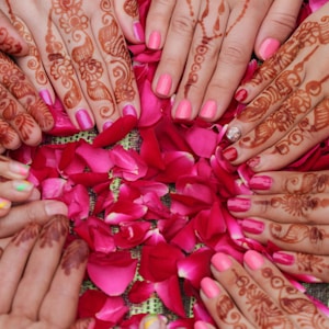 person with pink manicure holding pink and white floral textile