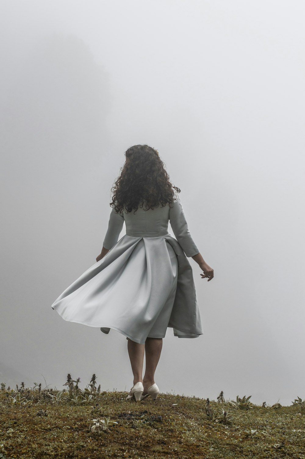 donna in vestito grigio in piedi