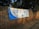 A large white and blue banner is stretched across a brick wall. The banner reads 'ELECTORAL COMMISSION ENSURING FREE AND FAIR ELECTIONS' with the logo of the Independent Electoral Commission of South Africa in the center. The surrounding area is shaded by trees.