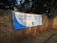A large white and blue banner is stretched across a brick wall. The banner reads 'ELECTORAL COMMISSION ENSURING FREE AND FAIR ELECTIONS' with the logo of the Independent Electoral Commission of South Africa in the center. The surrounding area is shaded by trees.