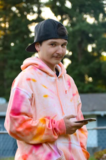 Happy customer wearing a colorful DTF printed hoodie outdoors.
