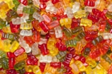 A colorful assortment of Creatina Gummy packs displayed on a wooden table.