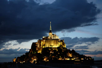 The majestic Mont Saint-Michel rising above the tidal waters at sunset.