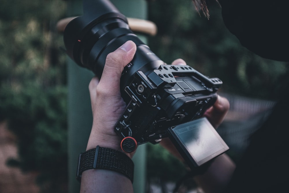 person holding black dslr camera