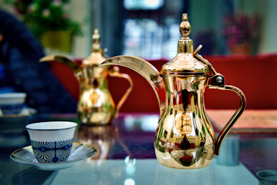 white and red floral ceramic teapot on table