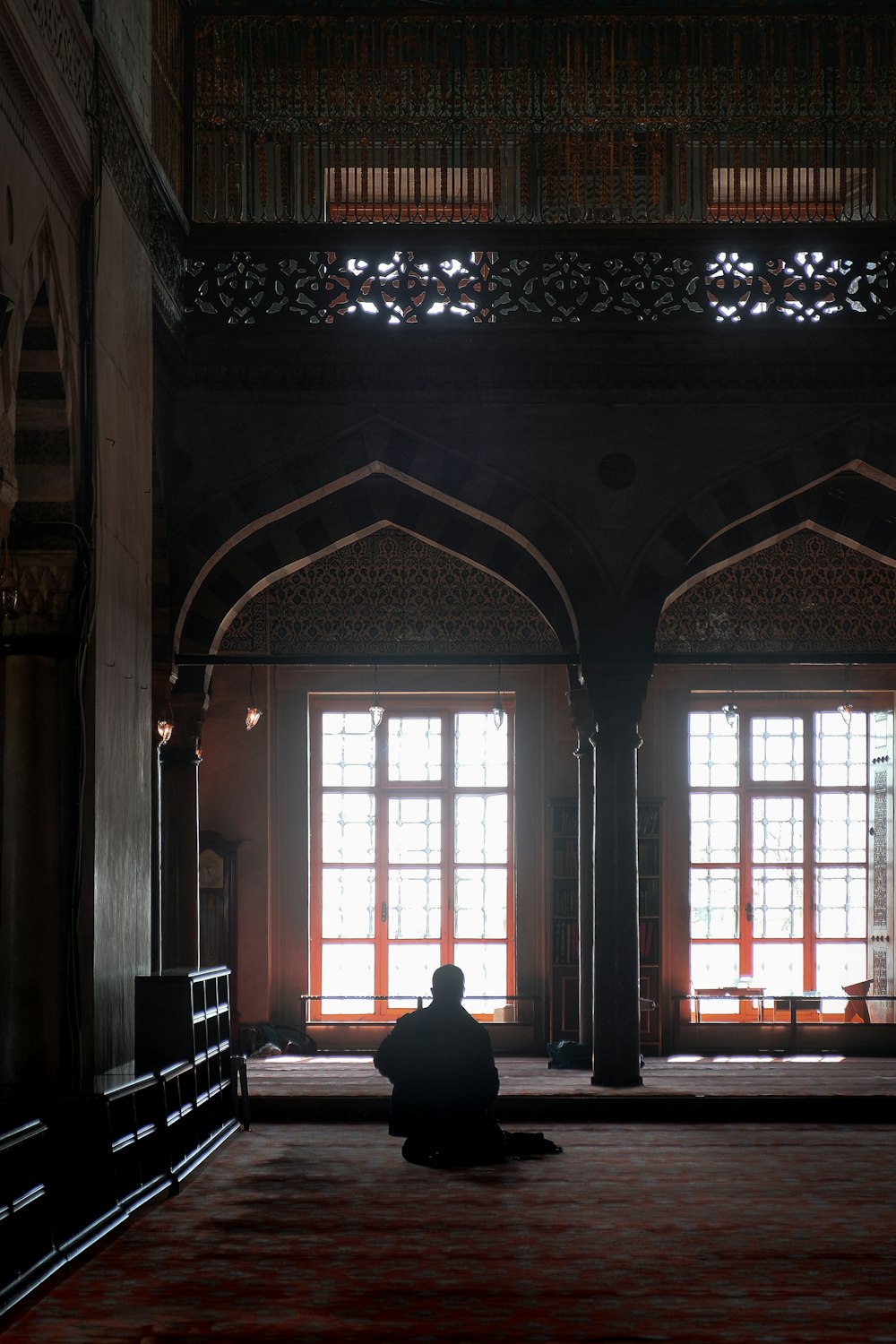 person in black jacket standing near window