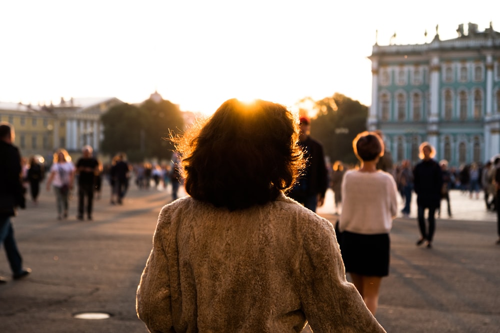 woman in white sweater standing on street during daytime