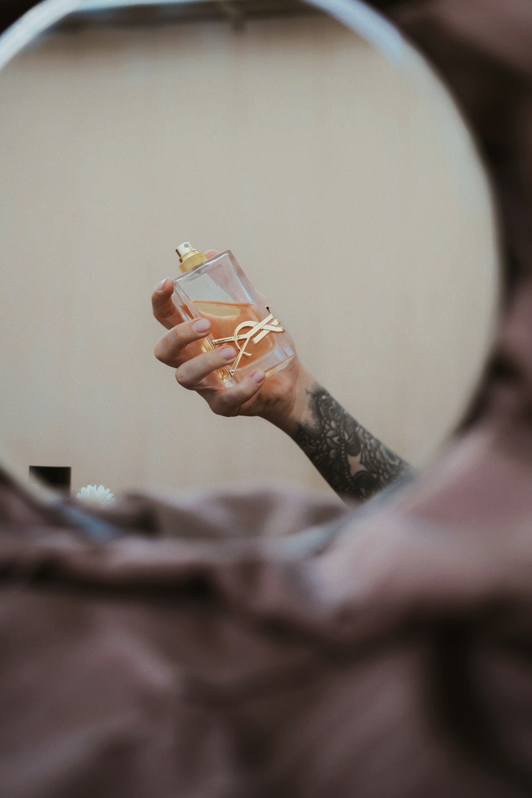 person holding clear drinking glass with brown liquid