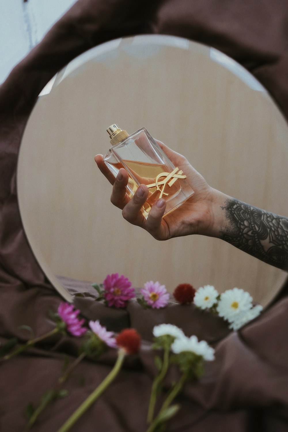 person holding clear glass bottle