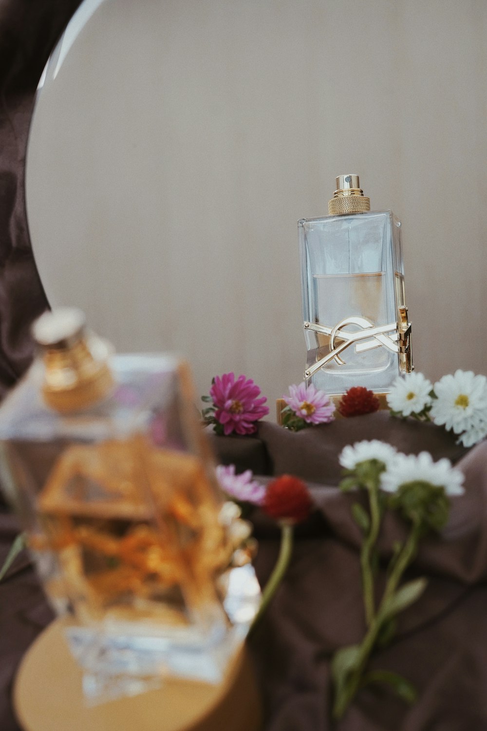 Frasco de perfume de vidrio transparente sobre mesa de madera marrón