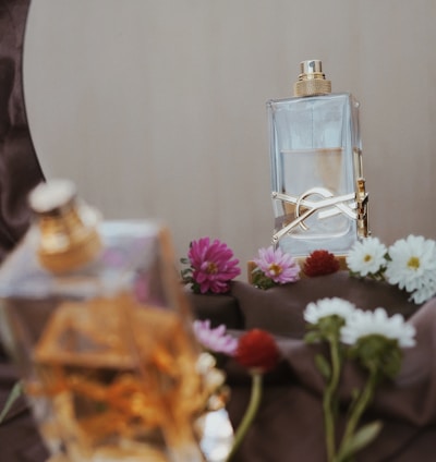 clear glass perfume bottle on brown wooden table