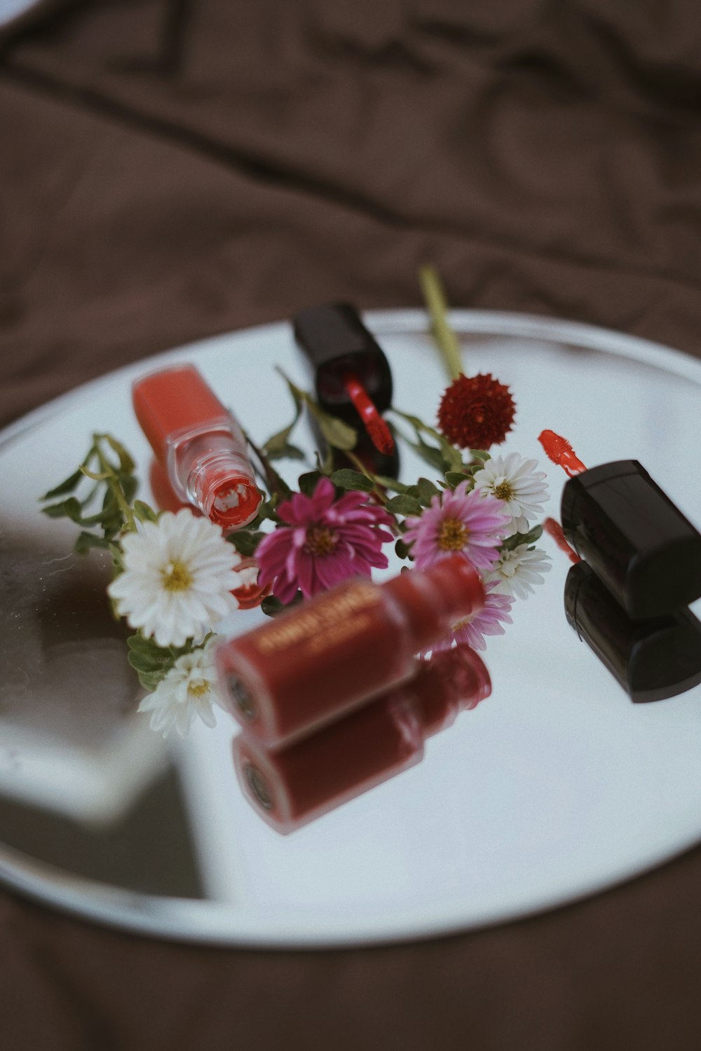 Esmalte de uñas rojo sobre placa de cerámica blanca