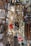 A shop display filled with various religious and decorative items, including hanging brass incense burners, colorful cords, and ornate religious icons with intricate detailing on the walls.