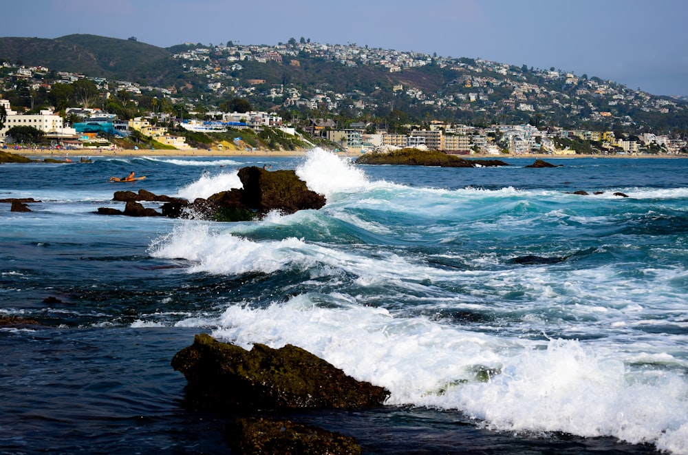 ocean waves crashing on rocky shore during daytime