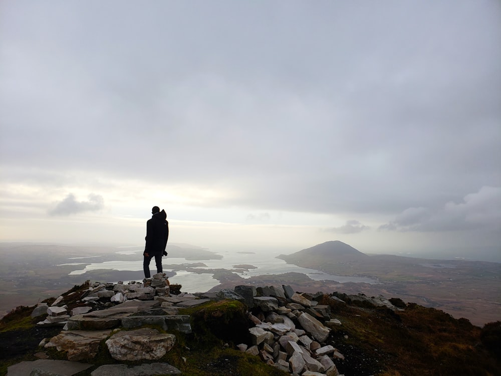 man standing on rocky mountain during daytime