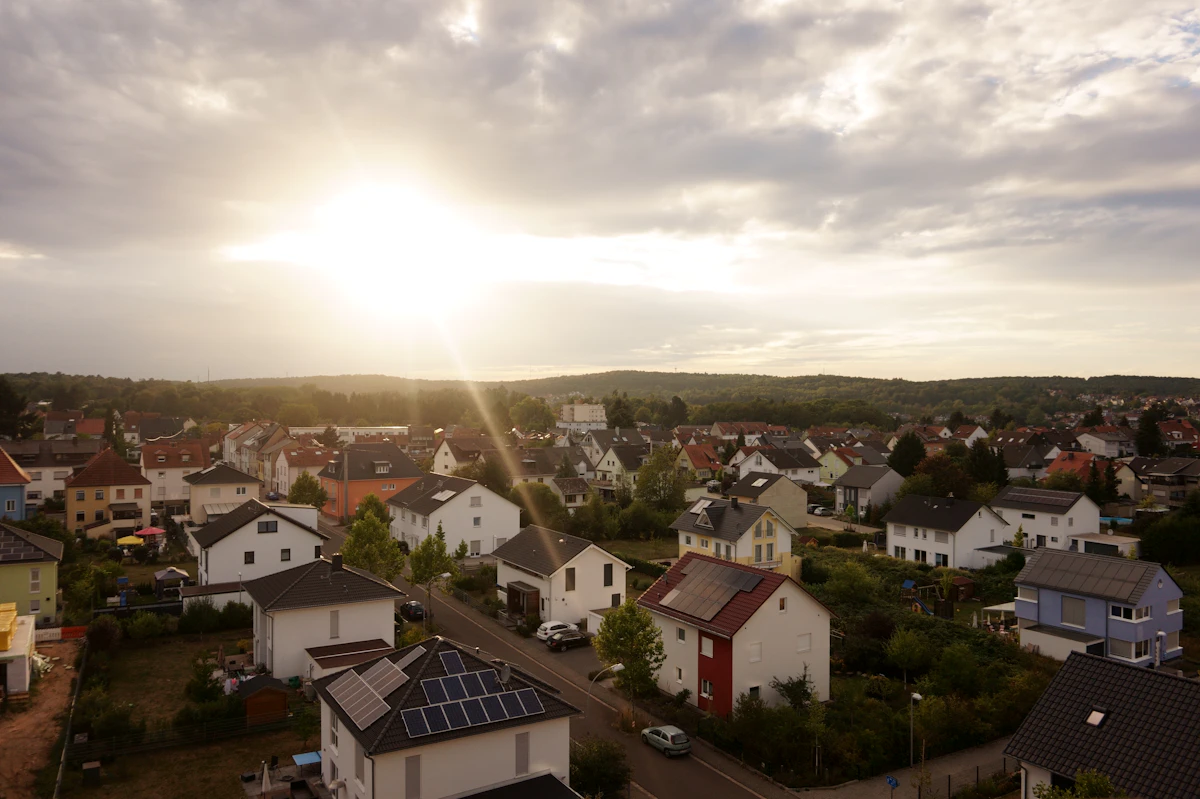 Blick über ein Dorf mit Häusern und Gärten im Morgenlicht