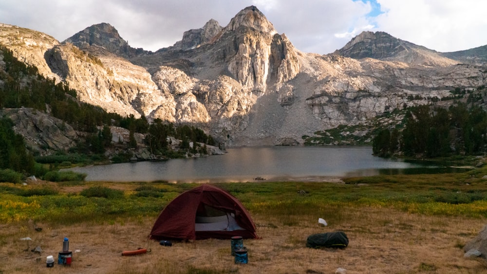 tenda cinza e preta perto do lago e da montanha