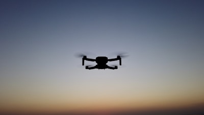 A drone equipped for defense operations, positioned on a rooftop at dawn.