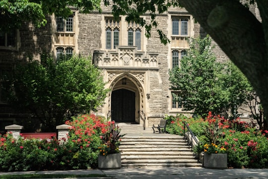 brown concrete building near green trees during daytime in McMaster University Canada